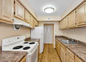 Thumbnail 9 of 21 - A kitchen with a white stove top oven and a white refrigerator.