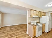 Thumbnail 20 of 21 - A kitchen with wooden floors and white appliances.