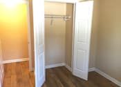 Thumbnail 3 of 21 - A white door is open to a room with a wooden floor.