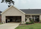 Thumbnail 1 of 7 - a brick house with a driveway and a garage door open