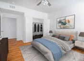 Thumbnail 9 of 25 - A bedroom with a bed, nightstand, and a painting on the wall.