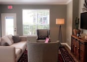 Thumbnail 19 of 25 - A living room with a couch, chair, and a television.