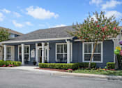 Thumbnail 5 of 25 - A blue house with a tree in front.