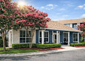 Thumbnail 3 of 25 - A house with a blue exterior and a red flowering tree in front.
