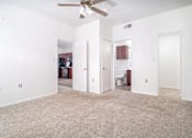 Thumbnail 12 of 25 - A room with a ceiling fan and carpeted floor.