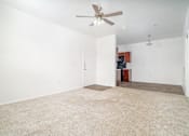 Thumbnail 11 of 25 - A room with a ceiling fan and carpeted floor.