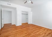 Thumbnail 13 of 25 - A room with wooden floors and white walls.