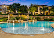 Thumbnail 22 of 61 - A large swimming pool with a fountain in the middle of it.