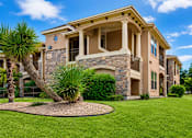 Thumbnail 3 of 61 - A large house with a stone and wood exterior and a landscaped front yard.