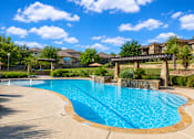 Thumbnail 6 of 61 - A large outdoor swimming pool with a bridge over it.