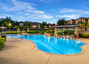 Thumbnail 42 of 61 - A large outdoor swimming pool with a slide and a fence surrounding the area.