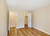 Thumbnail 19 of 21 - A room with two open doors and wooden floors.