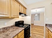 Thumbnail 6 of 21 - A kitchen with wooden cabinets and granite countertops.