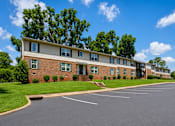 Thumbnail 1 of 4 - A large building with a parking lot in front of it.