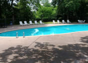 Thumbnail 6 of 6 - a swimming pool with chaise lounge chairs and trees in the background