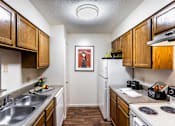 Thumbnail 36 of 38 - A kitchen with wooden cabinets and a white refrigerator.