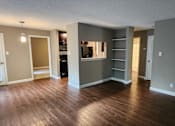 Thumbnail 31 of 38 - A living room with a grey wall and a wooden floor.