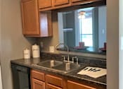 Thumbnail 37 of 38 - A kitchen with wooden cabinets and a granite countertop.