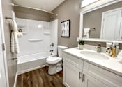 Thumbnail 32 of 38 - A white toilet sits in a bathroom next to a white sink.