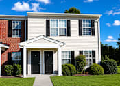 Thumbnail 3 of 8 - A house with a red brick section and a white siding section with a black door and windows.