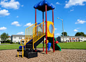 Thumbnail 4 of 8 - A playground with a blue and yellow slide and a red and yellow staircase.