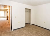 Thumbnail 5 of 8 - A room with a carpeted floor and a white wall with a door and a window.