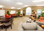 Thumbnail 8 of 8 - A living room with a grey couch and a wooden table.
