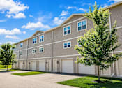 Thumbnail 19 of 19 - A large building with a grey facade and white garage doors.