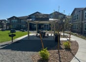 Thumbnail 64 of 65 - a park with a pavilion and picnic table in front of an apartment building