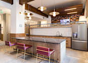 Thumbnail 14 of 22 - A kitchen with a bar area and two chairs.