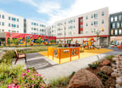 Thumbnail 10 of 22 - A playground area with a slide and a rock wall.