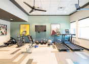 Thumbnail 16 of 22 - A gym with a variety of equipment including treadmills, exercise bikes, and weights.