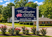 Thumbnail 2 of 4 - A sign for Washington Garden Apartments stands in front of a building.