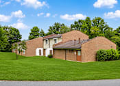 Thumbnail 7 of 7 - A house with a brown roof and a white garage door.