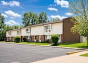 Thumbnail 6 of 7 - A row of houses with a parking lot in front.