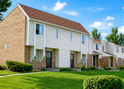 Thumbnail 1 of 7 - A row of houses with brown roofs and white walls.