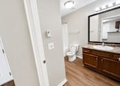 Thumbnail 9 of 12 - A bathroom with a toilet, sink, and mirror.