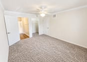 Thumbnail 5 of 12 - A room with a carpeted floor and a ceiling fan.
