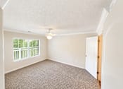 Thumbnail 10 of 12 - A room with a carpeted floor and a window with a view of a green fence.