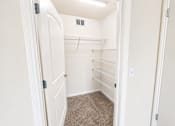 Thumbnail 4 of 12 - A white closet with a carpeted floor and shelves.
