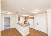 Thumbnail 2 of 12 - A kitchen with white appliances and wooden cabinets.