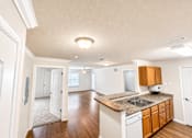 Thumbnail 7 of 12 - A kitchen with white cabinets and a granite countertop.