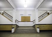 Thumbnail 17 of 39 - A staircase with a white wall and a brown step.