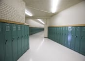 Thumbnail 27 of 39 - A long hallway with green lockers on either side.