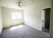 Thumbnail 2 of 39 - A room with a ceiling fan and a window letting in sunlight.