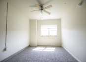 Thumbnail 3 of 39 - A room with a ceiling fan and a window letting in sunlight.