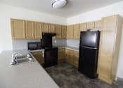 Thumbnail 9 of 39 - A kitchen with black appliances and wooden cabinets.
