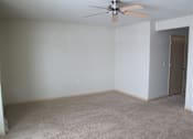 Thumbnail 8 of 12 - A room with a ceiling fan and carpeted floor.