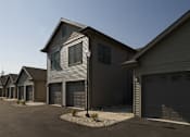 Thumbnail 7 of 12 - A row of houses with garages and driveways.