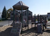 Thumbnail 6 of 12 - A playground with a slide, swings, and a gazebo.